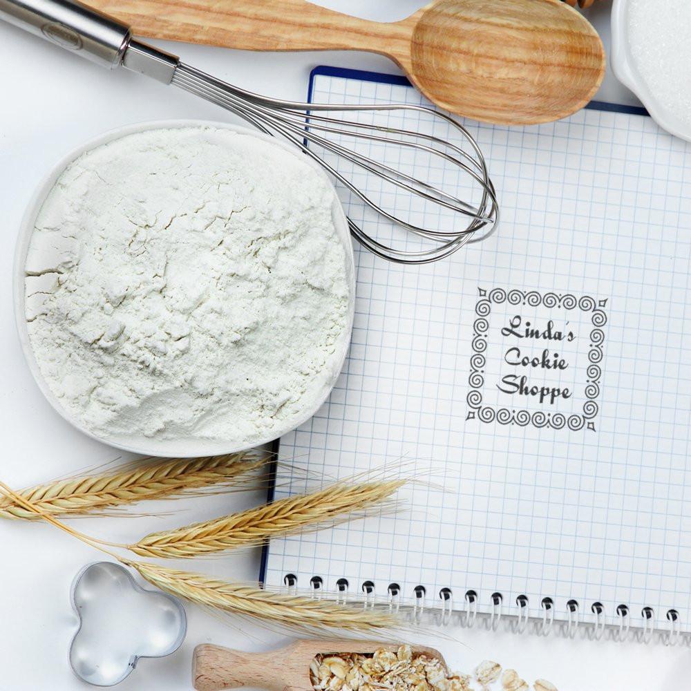Custom bakery rubber stamp for Lindas Cookie Shoppe on a recipe notebook, ideal for cookie packaging and branding.