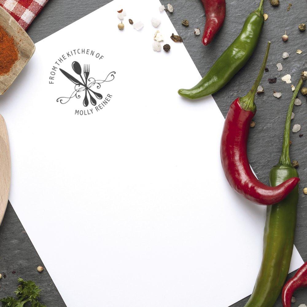 Custom kitchen rubber stamp on recipe paper with utensils logo, perfect for personalized food labels and homemade gifts.