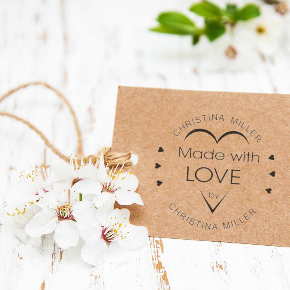 Handmade rubber stamp design on kraft gift tag reading Made with Love by Christina Miller, styled with white blossoms.