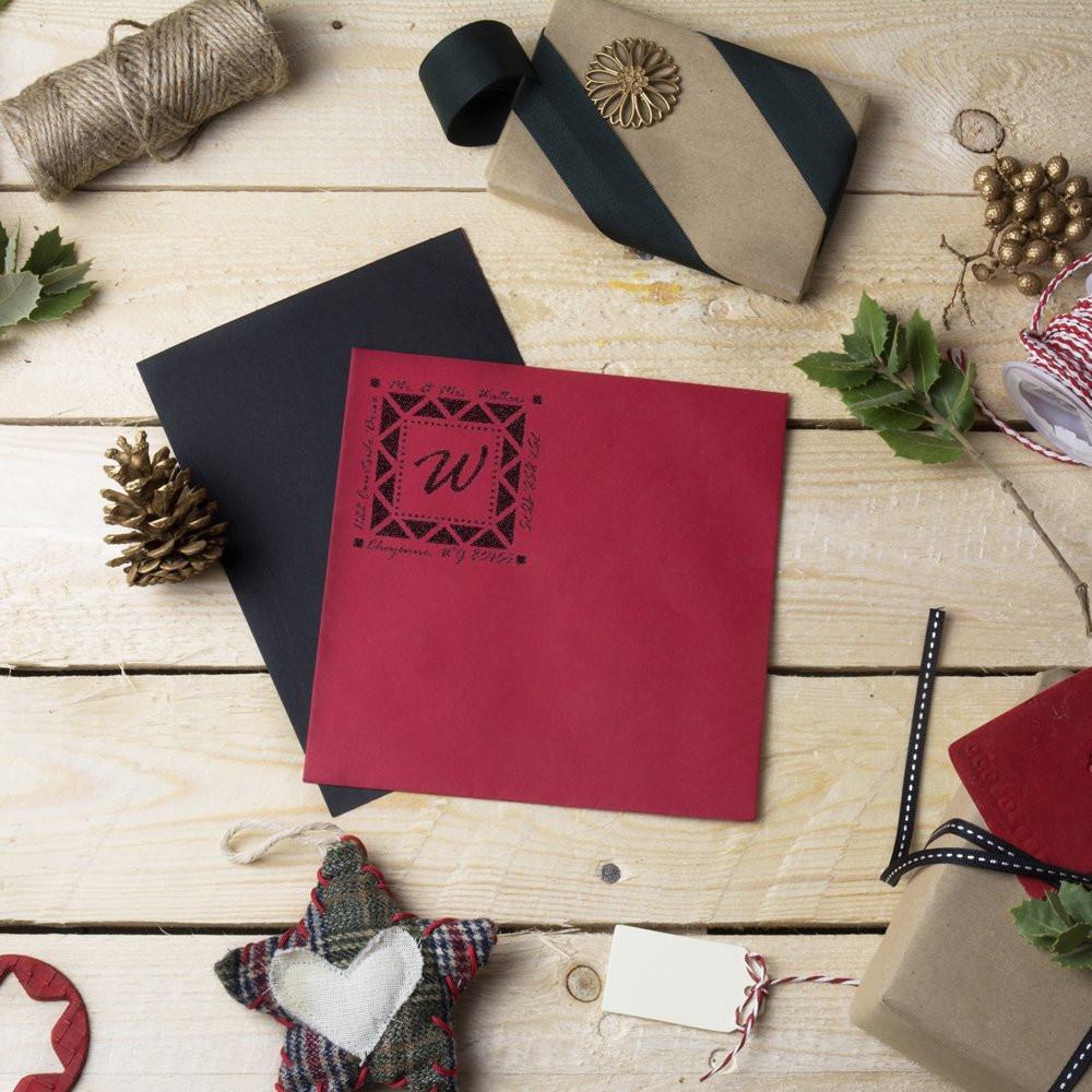 Custom rubber stamp impression on festive holiday gift packaging, adding monogram branding to cards, tags and wrapped presents.