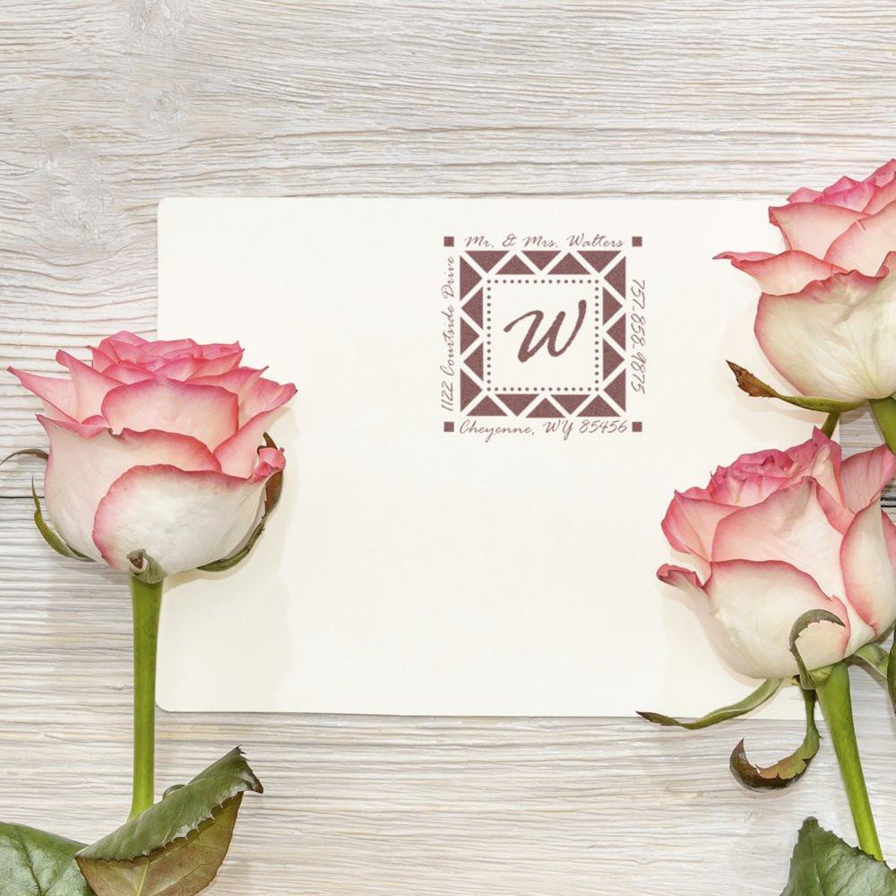 Custom wedding return address rubber stamp on envelope with pink roses and monogrammed family address.