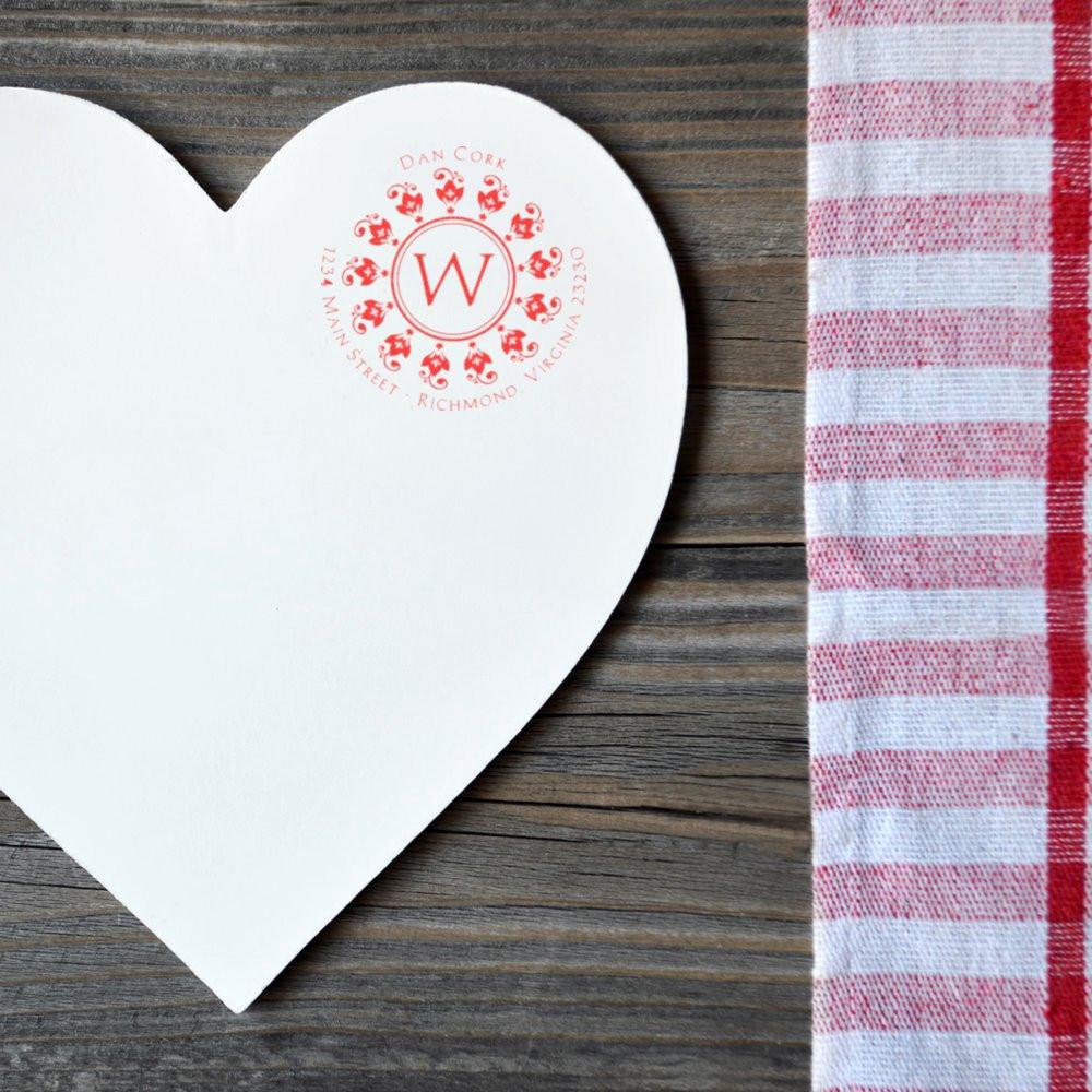 Heart-shaped note card stamped with a red custom monogram rubber stamp, ideal for personalized wedding stationery and branding.