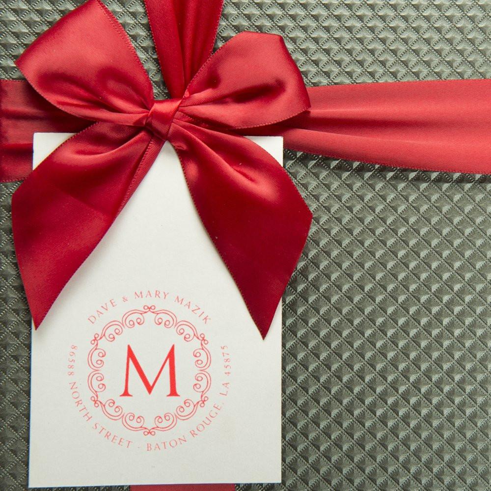 Red satin ribbon gift bow with a white boutique tag featuring the M logo and North Street, Baton Rouge, LA details