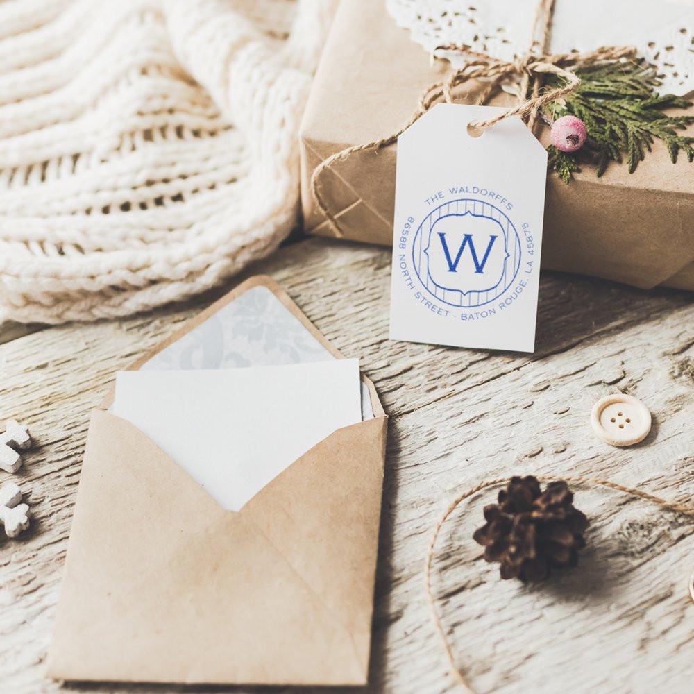 Custom rubber stamp logo on gift tags and envelope, adding a branded, personalized touch to rustic stationery and packaging.