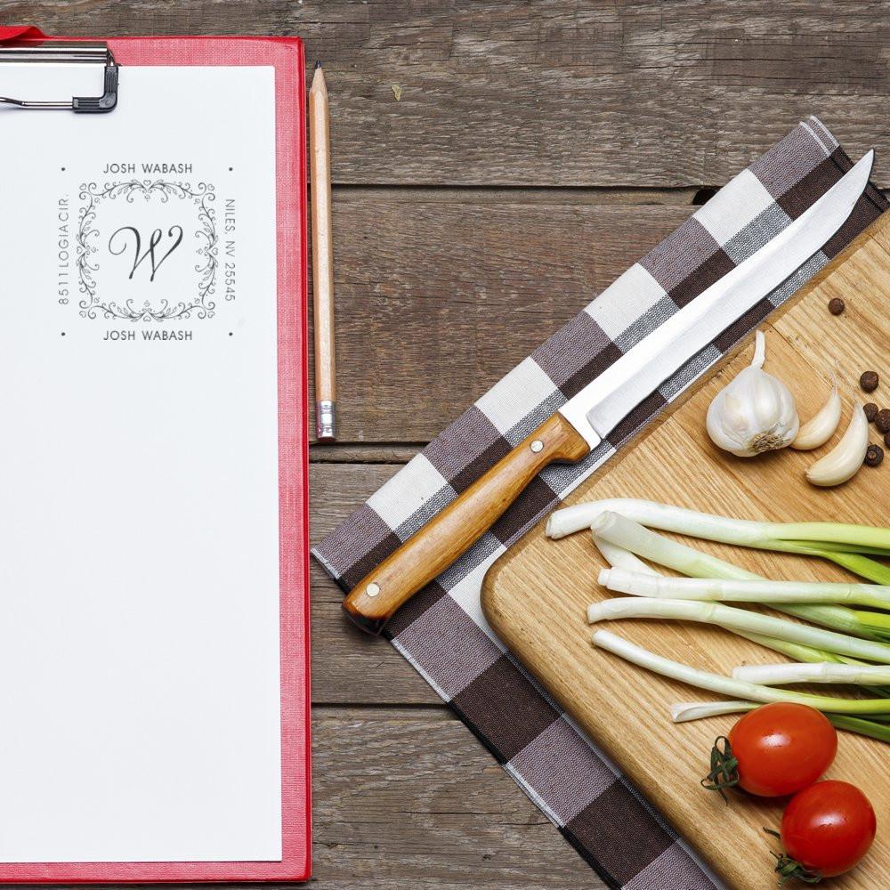 Personalized return address rubber stamp on clipboard, perfect for wedding invitations, envelopes, and monogram stationery.