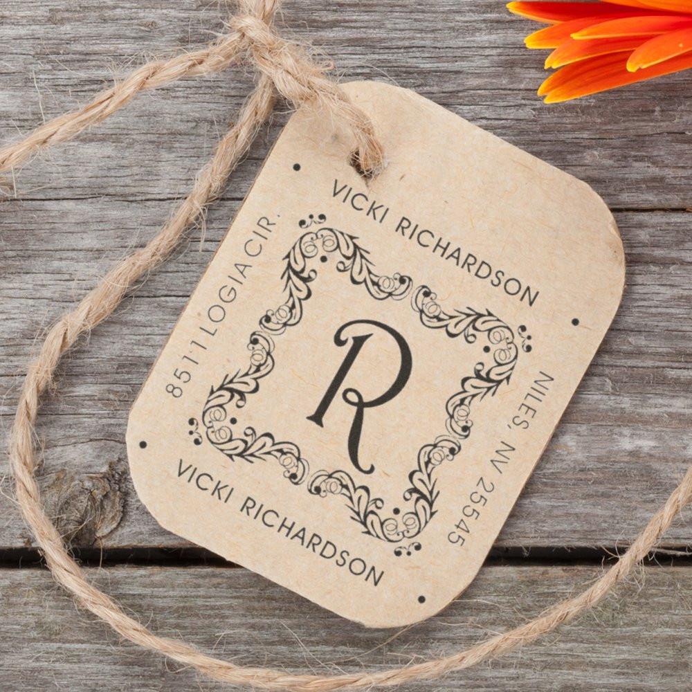 Custom return address rubber stamp with monogram R and floral design, shown on a kraft tag for personalized wedding or business use.
