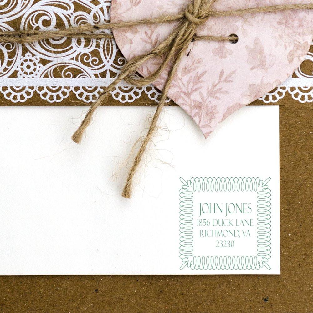 Custom return address rubber stamp on a white envelope with decorative border for wedding invitations and stationery.