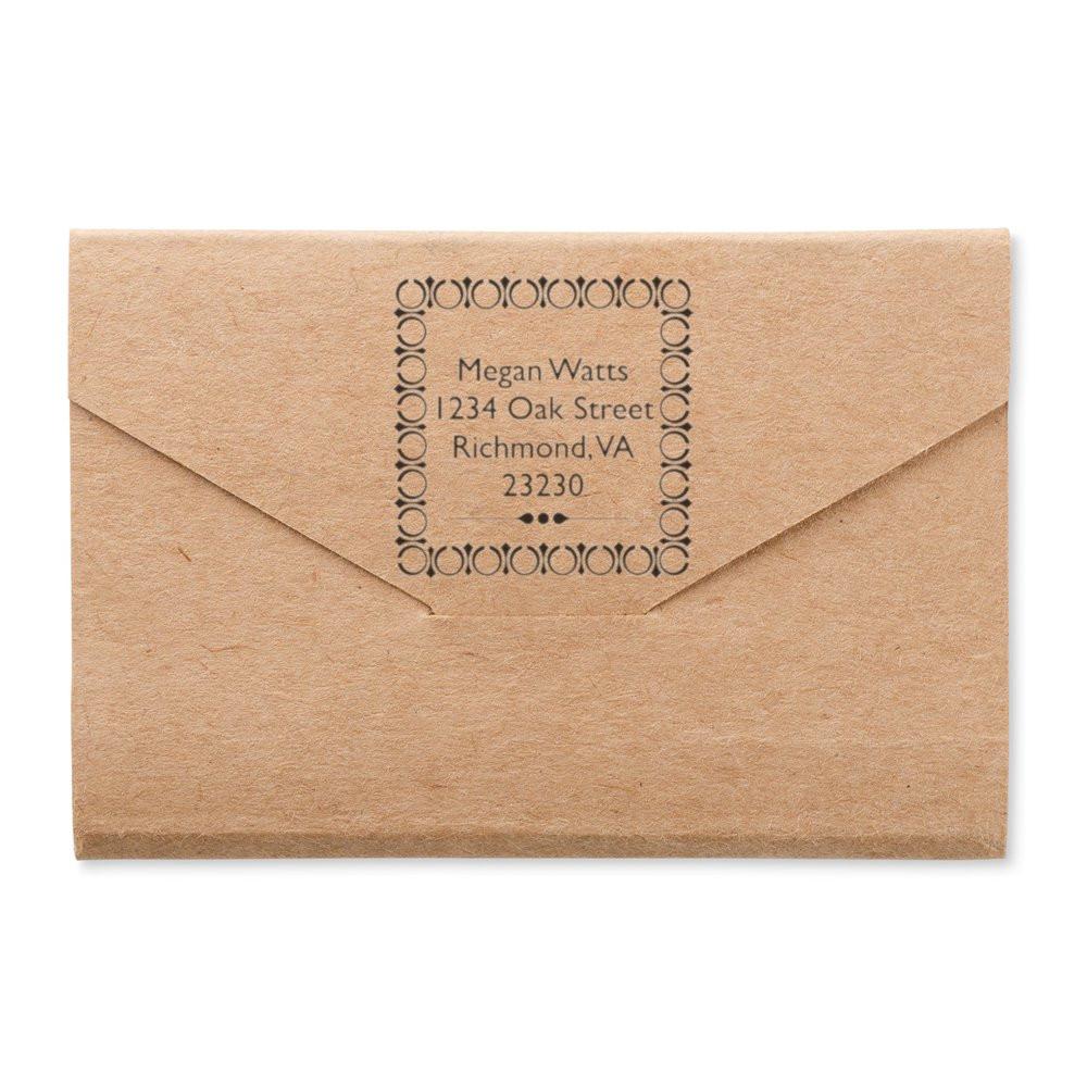 Custom return address rubber stamp on kraft envelope with decorative name and address imprint.
