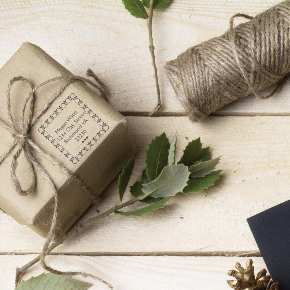 Custom address rubber stamp on kraft gift wrapping with twine, perfect for personalized packaging and eco-friendly branding.