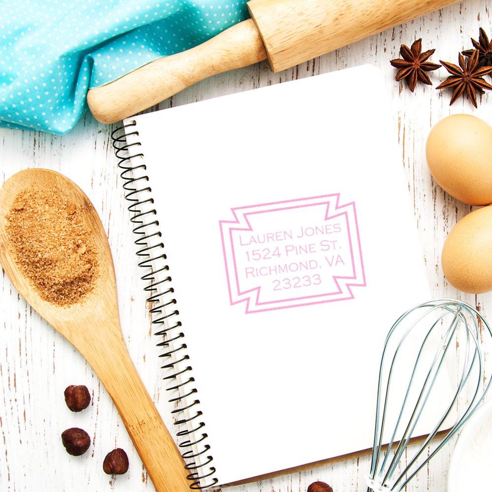 Custom address rubber stamp impression on notebook, featuring a personalized return address stamp for home or business use.
