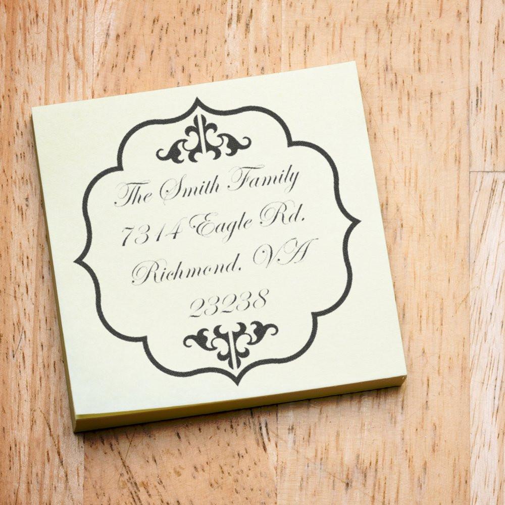 Custom decorative address rubber stamp for family mailings with monogram frame and return address imprint.