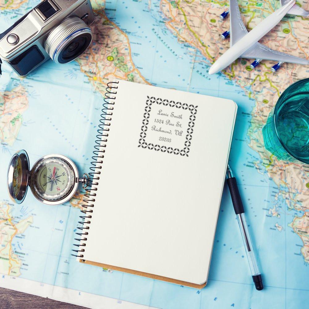 Custom address rubber stamp impression on a travel notebook, ideal for personalized mailing and stationery branding.