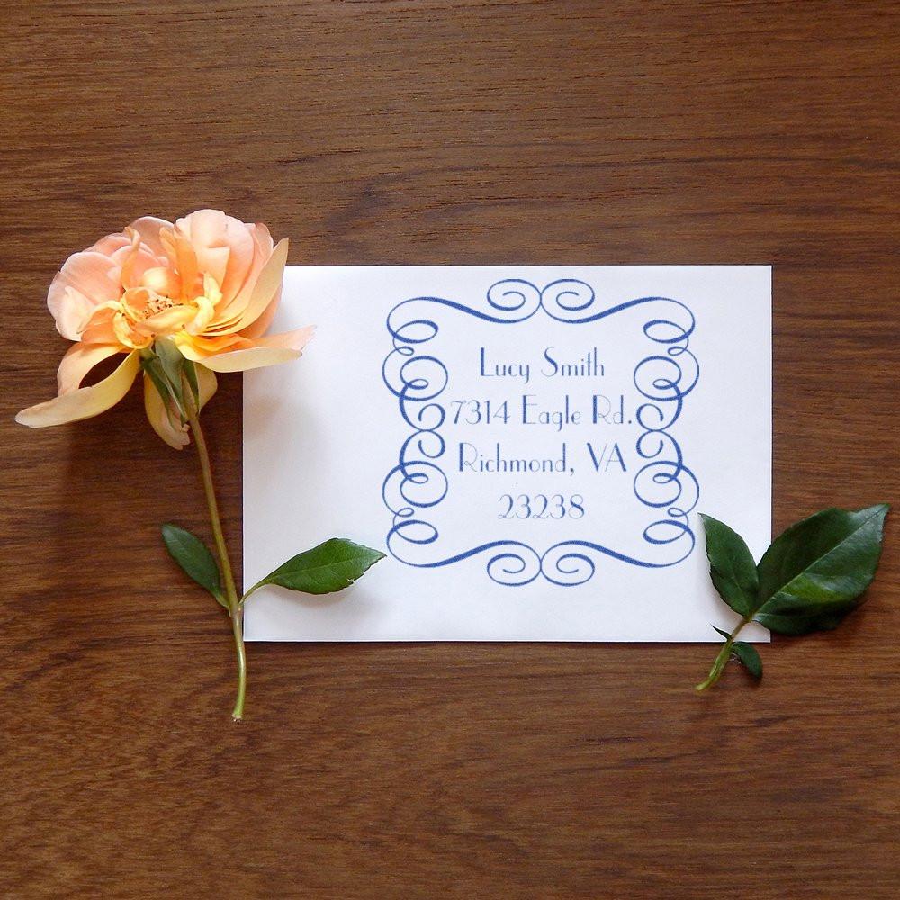 Custom return address rubber stamp with ornate frame, used for personalized wedding invitations and stationery.