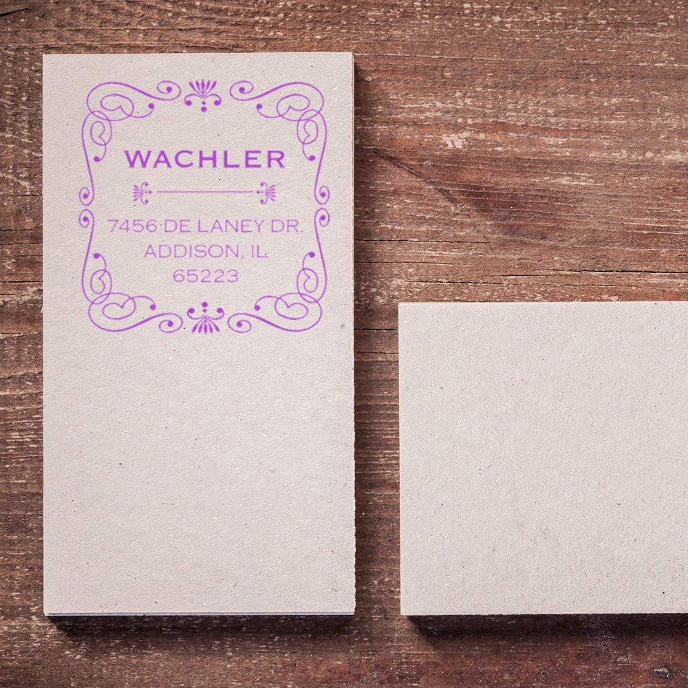 Custom return address rubber stamp with floral border, featuring Wachler address imprint on paper beside a blank card.
