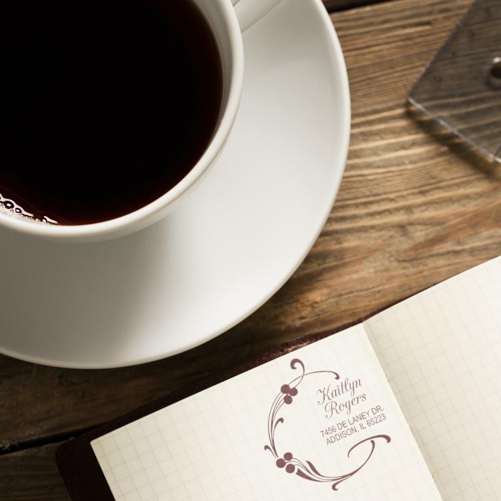 Custom return address rubber stamp on a notebook beside coffee, perfect for personalized stationery and mailings.