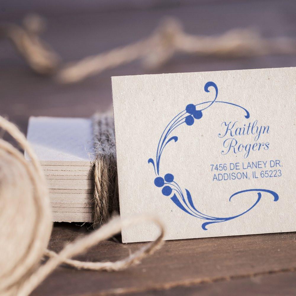 Personalized return address rubber stamp with floral design and blue ink impression on cardstock