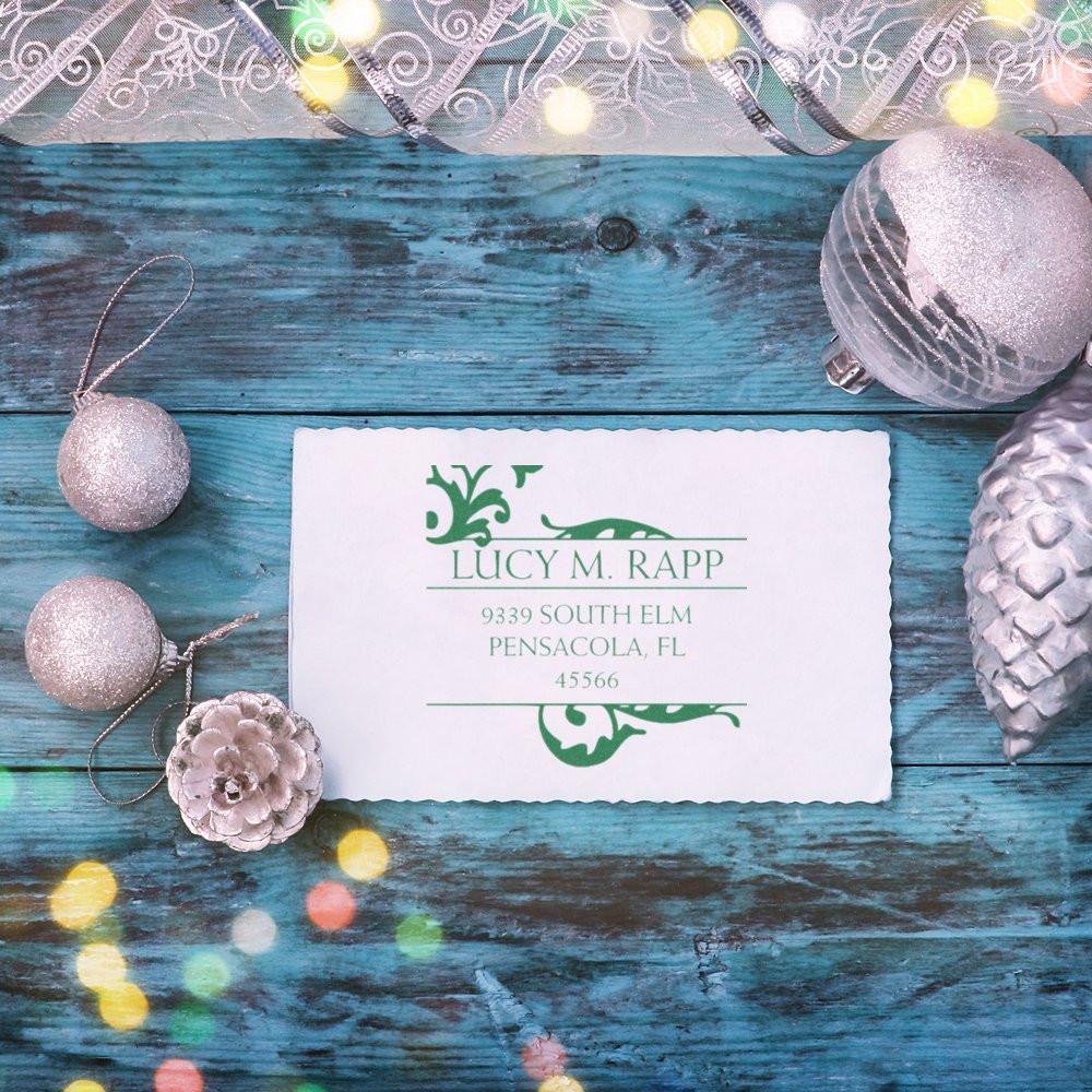 Custom return address rubber stamp with decorative monogram on holiday stationery display.