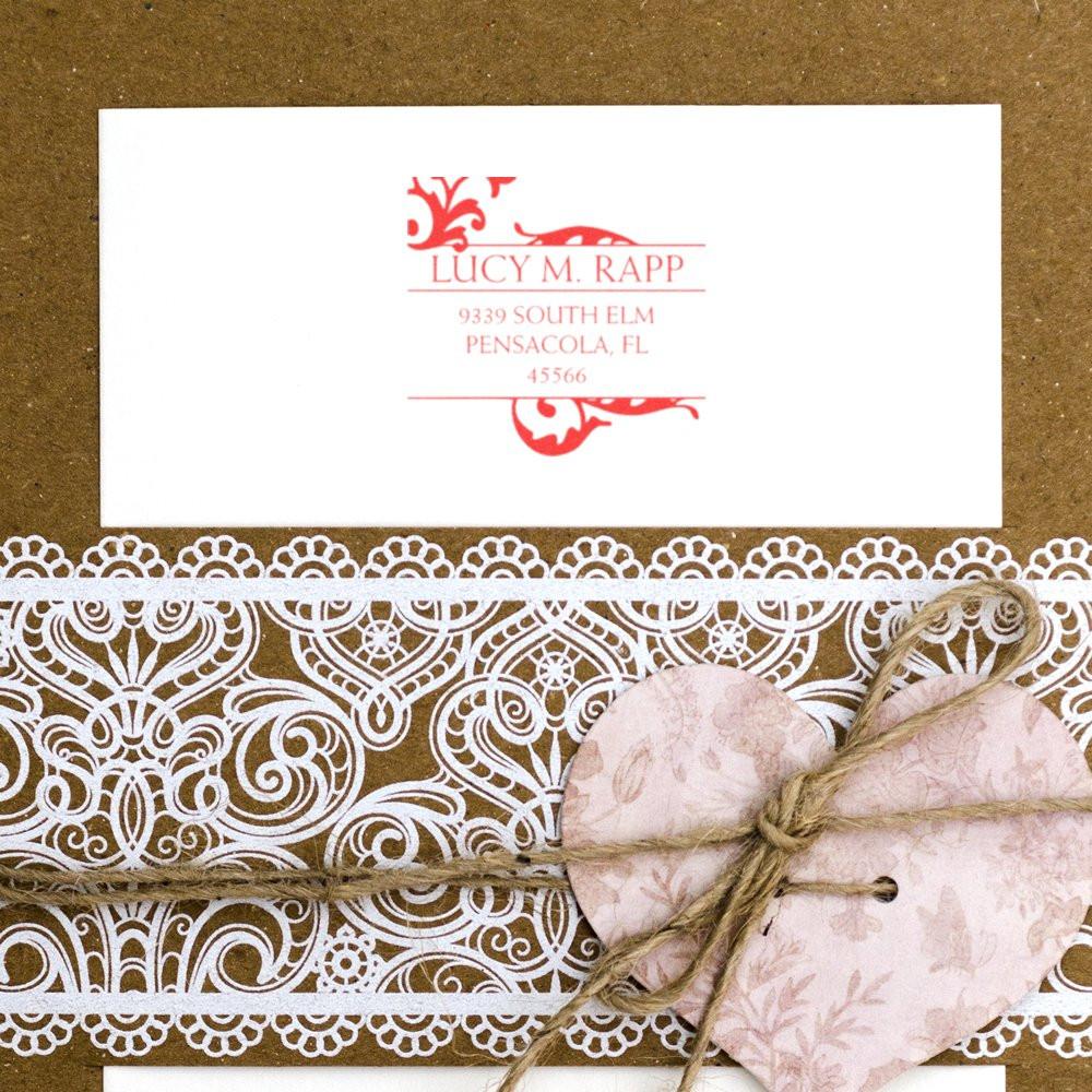 Custom rubber address stamp on elegant wedding invitation envelope with lace and heart embellishment