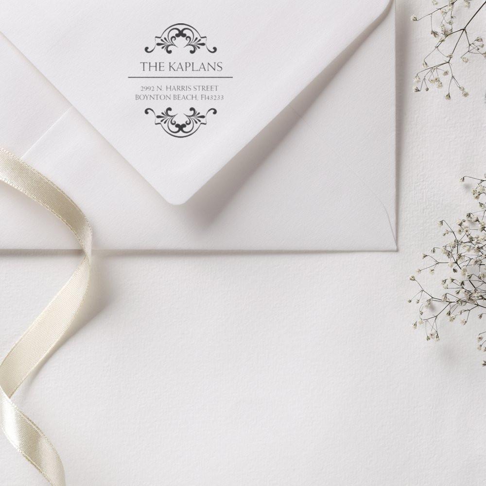 Personalized return address rubber stamp on a wedding invitation envelope with elegant floral monogram