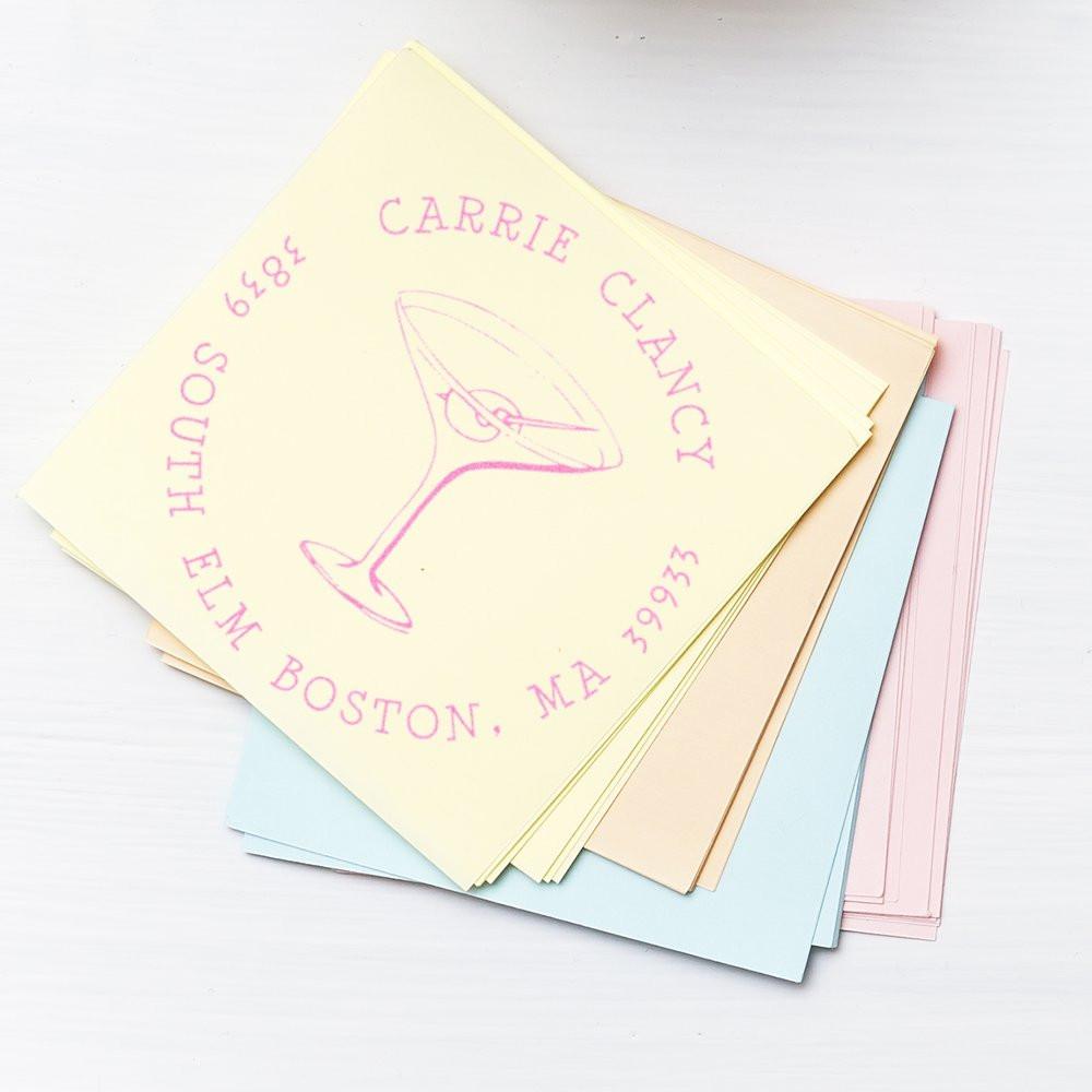 Custom rubber address stamp for Carrie Clancy, South End Boston, MA, with martini glass logo on pastel cards.