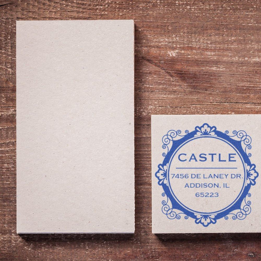 Custom rubber stamp imprint on cardstock beside blank card, featuring decorative address stamp for business branding.