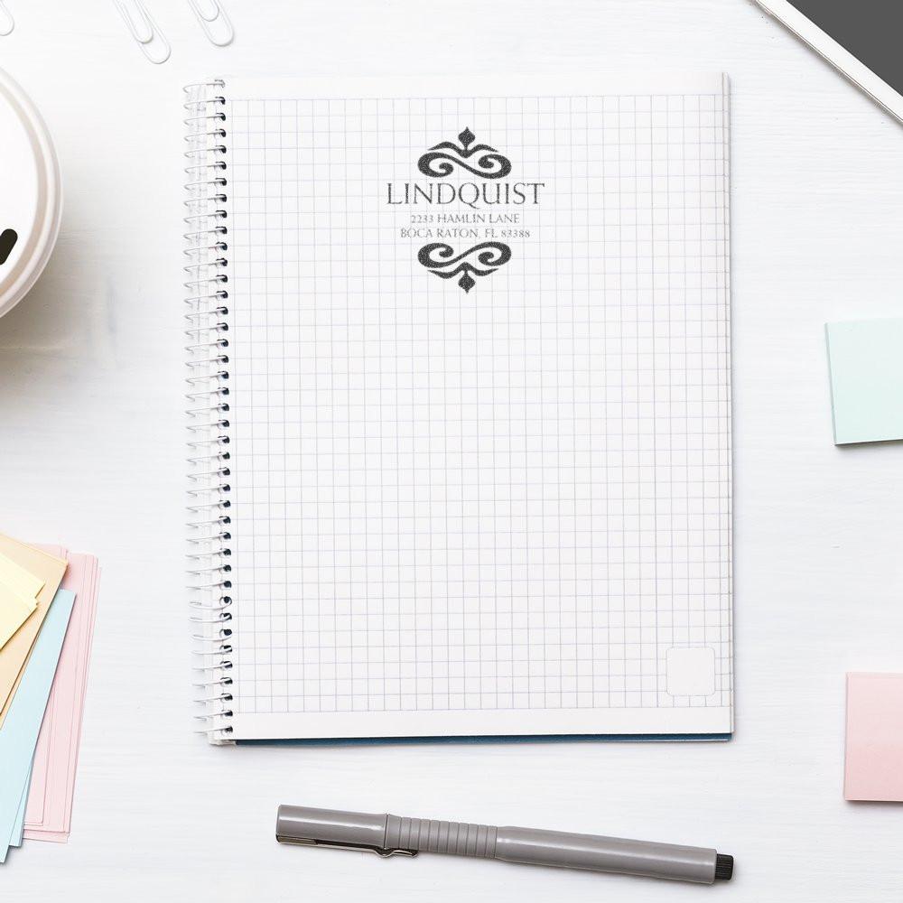 Custom rubber address stamp on graph notebook for branded stationery and personalized correspondence.