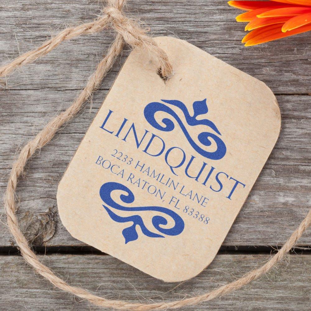 Custom rubber stamp imprint on kraft paper tag for Lindquist, featuring business logo and address with rustic twine.