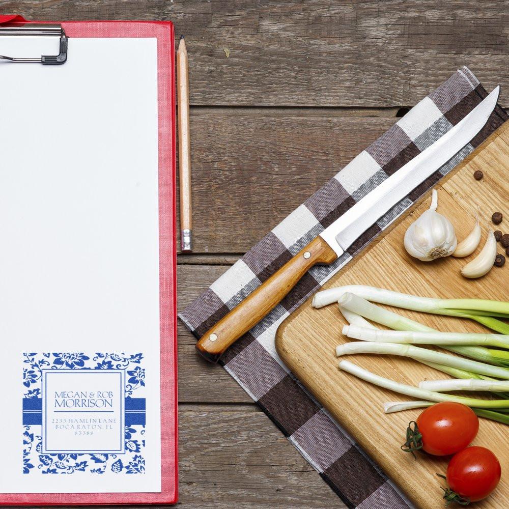 Custom rubber stamp impression on clipboard paper, showcasing a personalized address stamp for kitchen-themed branding.