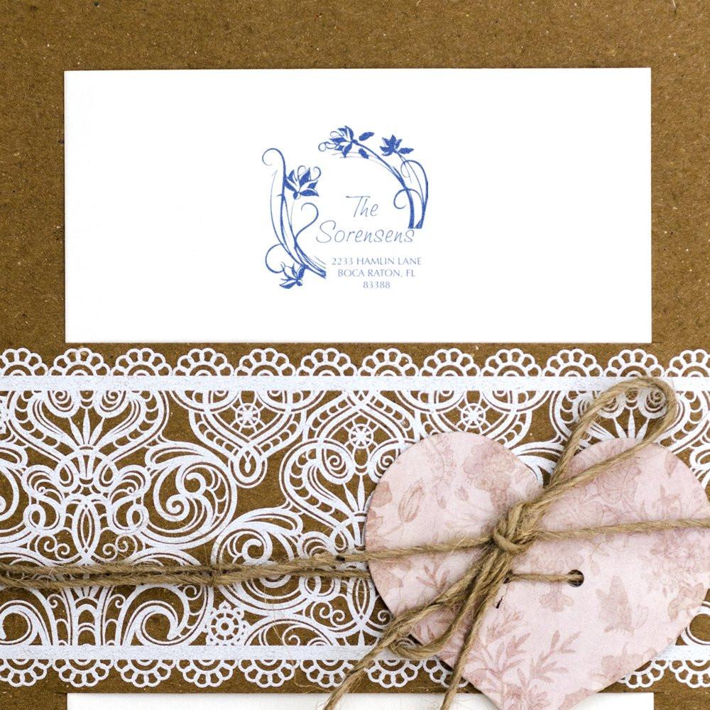 Custom wedding address rubber stamp on envelope, featuring floral monogram for personalized invitations and stationery.