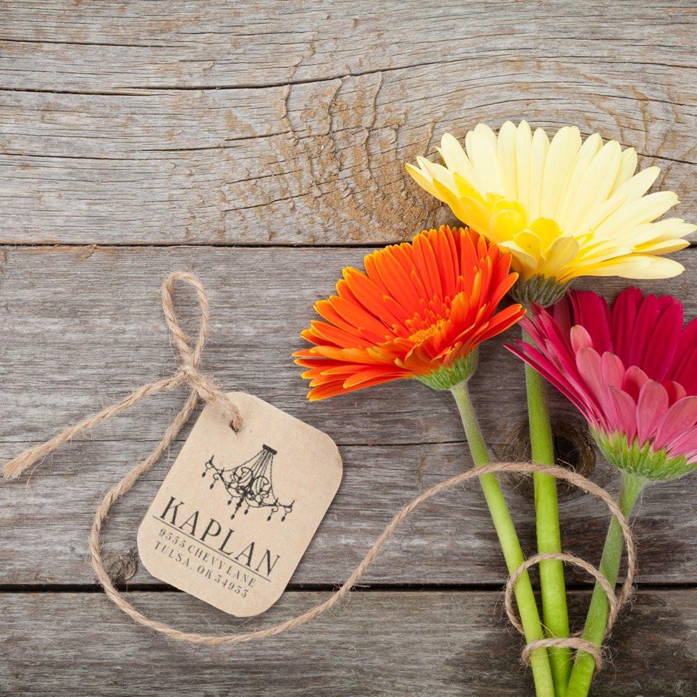 Gerbera daisy bouquet with Kaplan floral gift tag on rustic wood, ideal spring wedding, birthday, or thoughtful gifting.