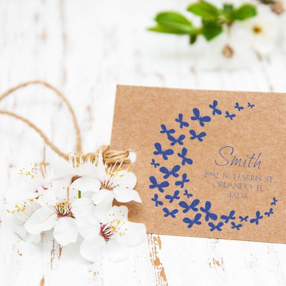 Personalized butterfly return address rubber stamp on kraft tag with floral styling.