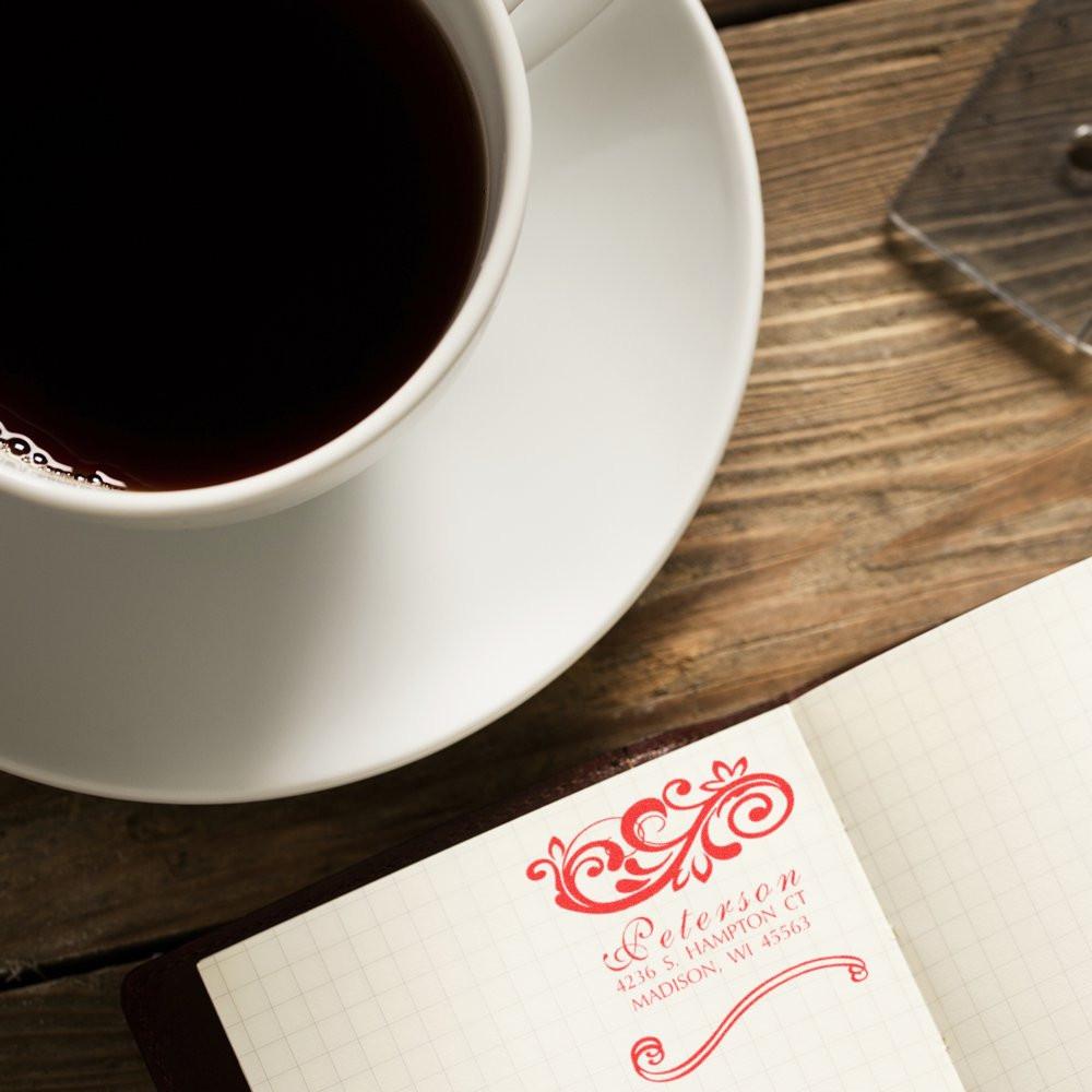 Fresh black coffee in a white cup on a rustic table beside a notebook and business card for caf branding.