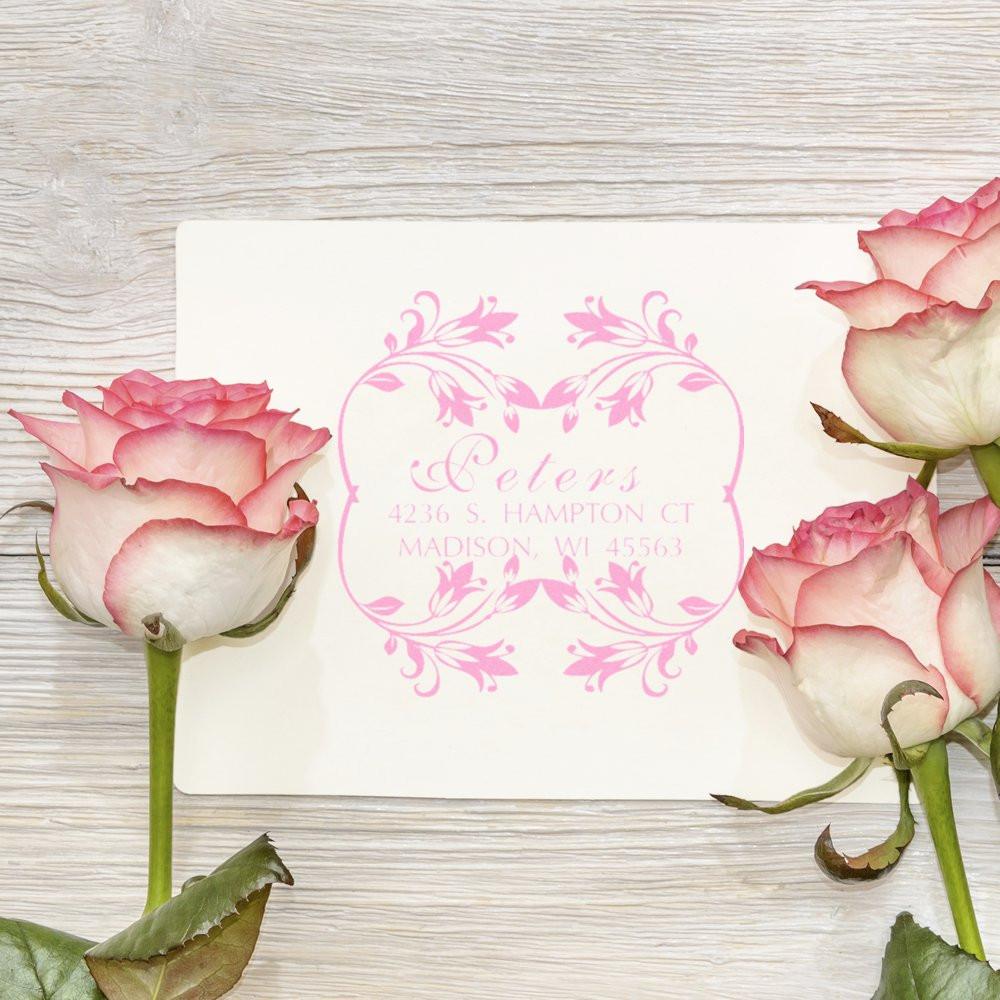 Personalized floral address rubber stamp for wedding invitations, featuring pink ink and elegant custom envelope stamping.