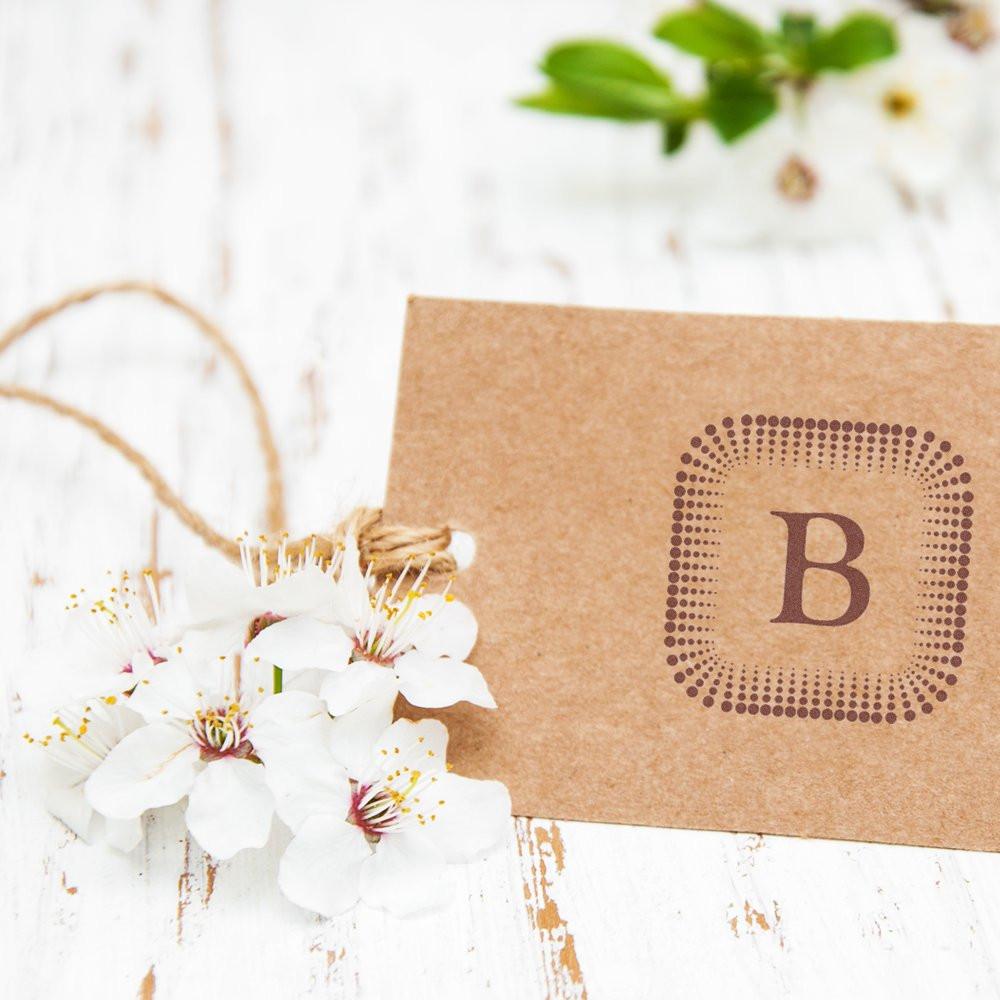 Custom monogram B rubber stamp on kraft paper gift tag with flowers, ideal for personalized stationery and packaging.