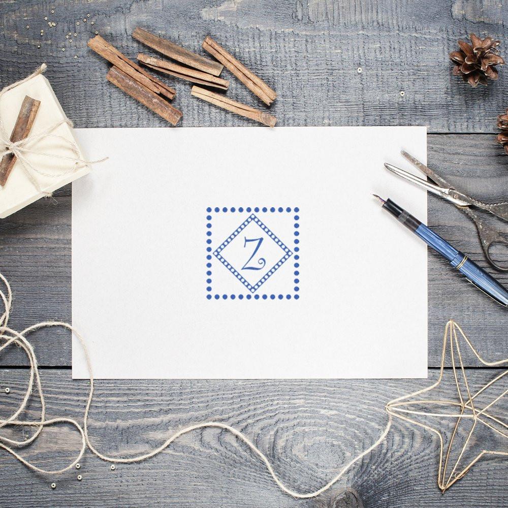 Custom monogram rubber stamp with blue letter Z on white stationery, perfect for handmade branding and packaging.