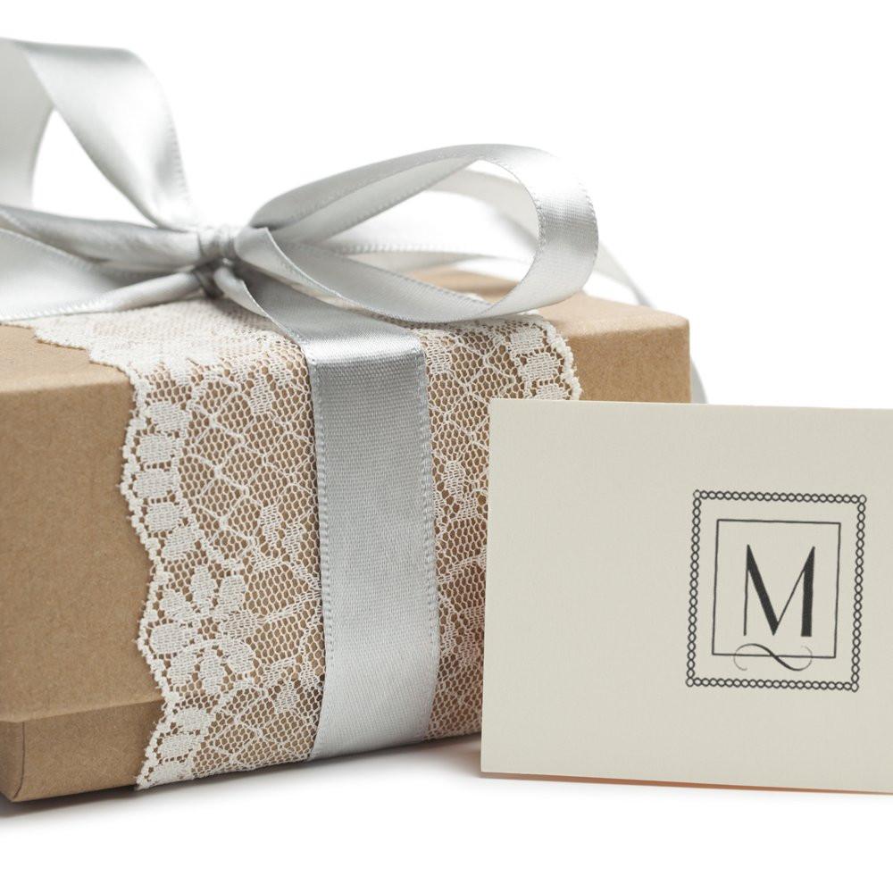 Personalized monogram rubber stamp on a wrapped gift, ideal for custom wedding favors, branding, and elegant packaging.