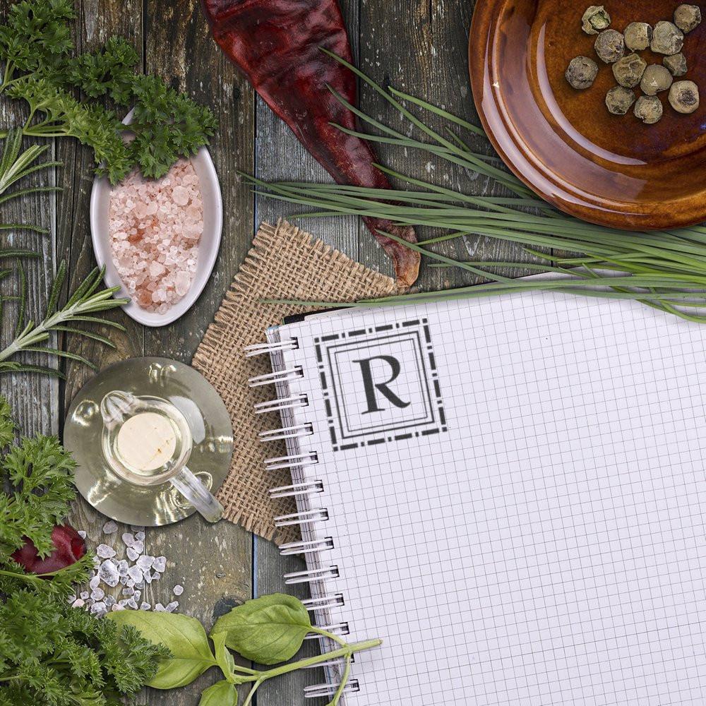 Custom letter R rubber stamp on notebook with herbs and spices for rustic recipe or kitchen branding.