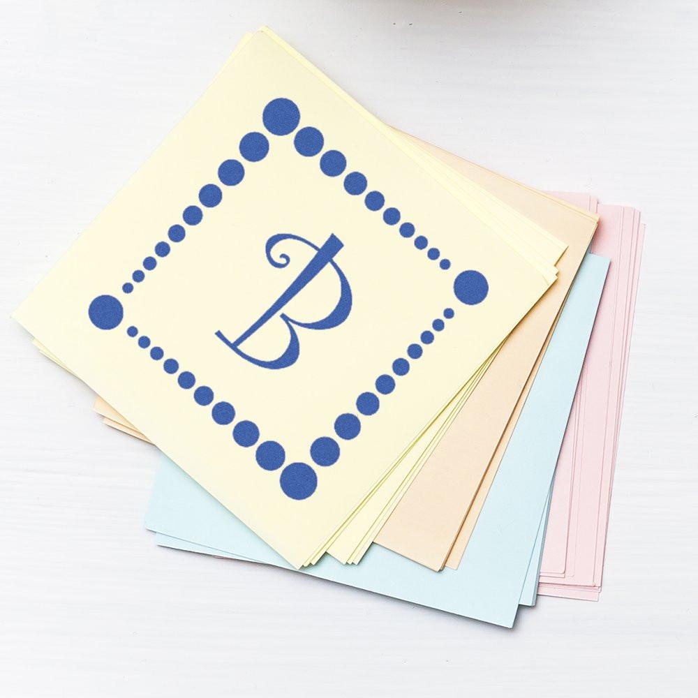 Custom monogram rubber stamp with letter B and dotted border on pastel stationery cards.