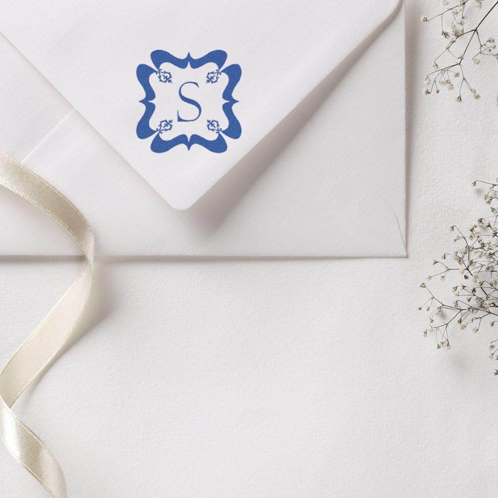 Personalized monogram S rubber stamp on a white envelope for elegant wedding invitations and custom stationery.