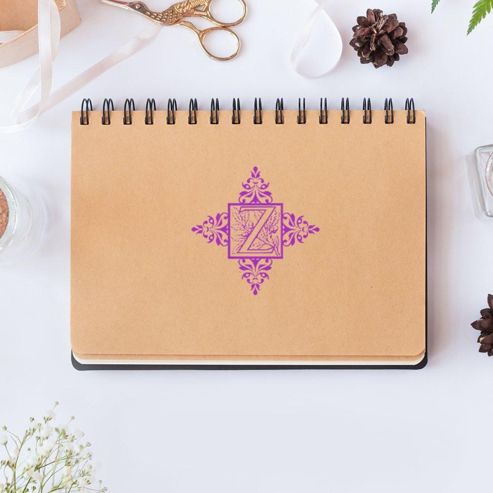 Purple decorative Z rubber stamp on kraft notebook, ideal for personalized monogram branding and stationery.
