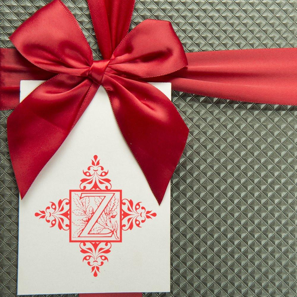 Custom monogram Z rubber stamp on a white gift tag with red satin bow, ideal for personalized packaging and holiday gifts.