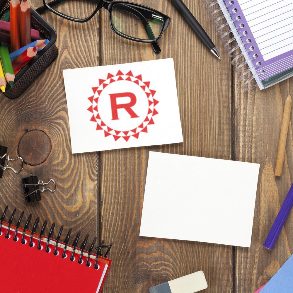 Custom rubber stamp logo on paper with office supplies, showing branded stationery and a personalized stamp imprint.