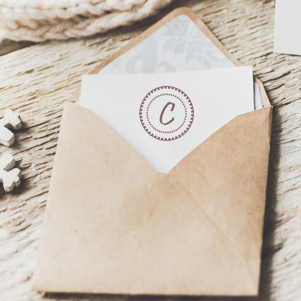 Custom monogram rubber stamp with letter C on an envelope, perfect for wedding invitations, branding, and stationery.