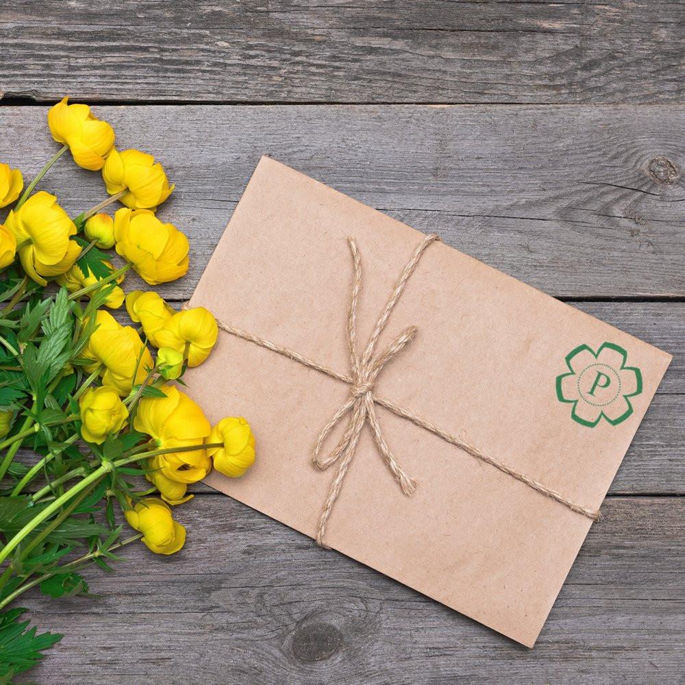 Floral custom rubber stamp on kraft paper packaging tied with twine, perfect for branding stationery and handmade products.