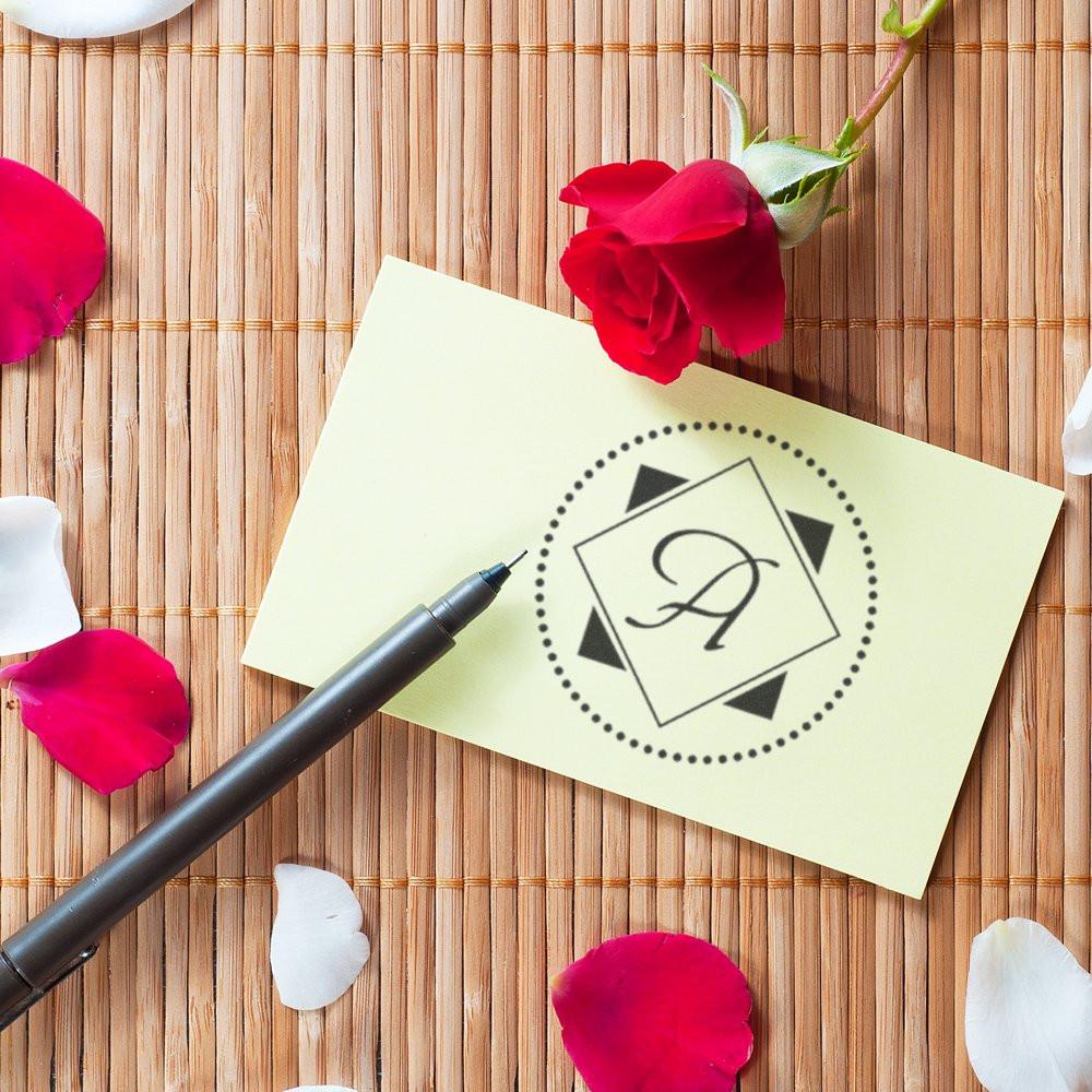 Custom monogram rubber stamp on stationery with rose petals, ideal for wedding invitations and personalized branding.