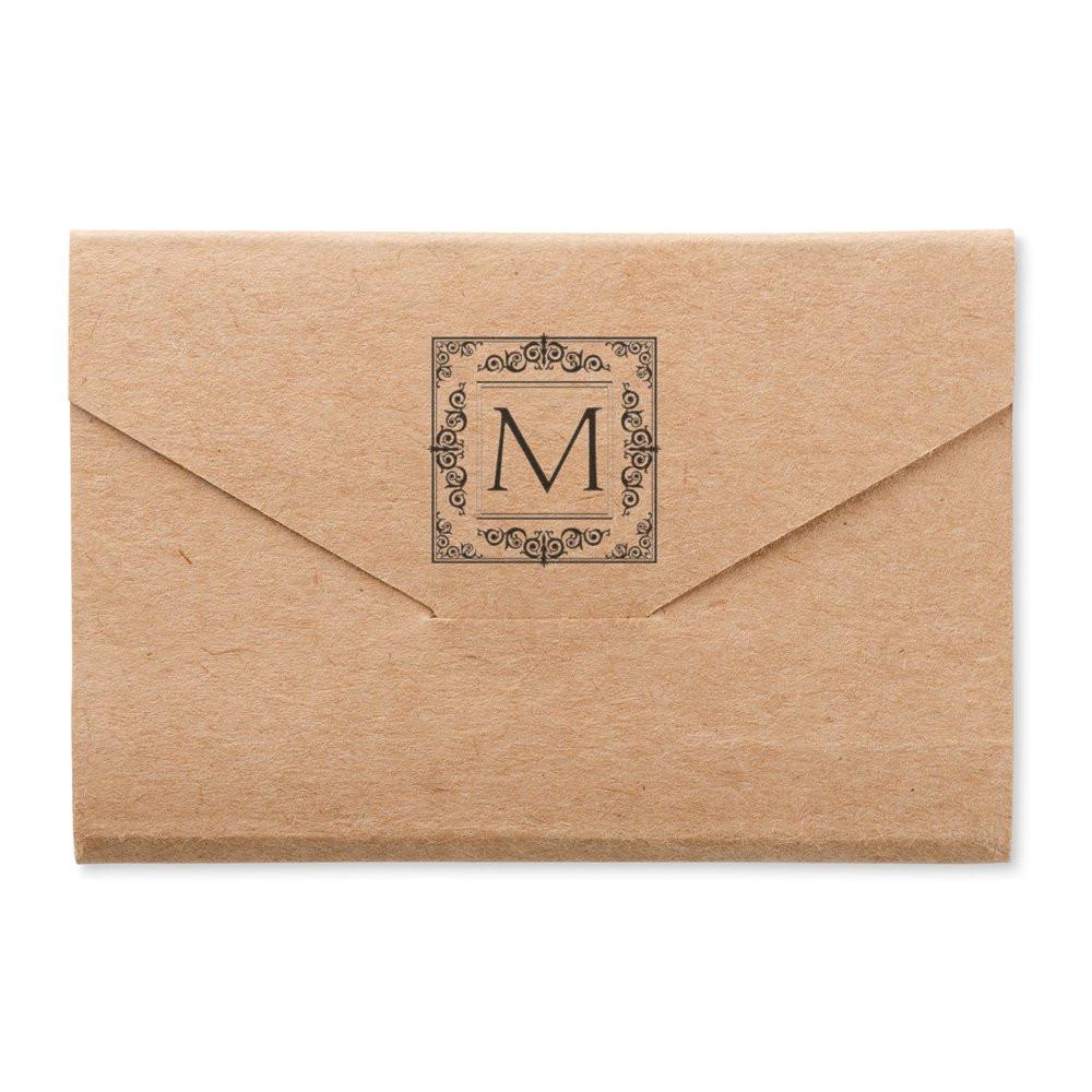 Monogram rubber stamp on kraft envelope for custom wedding or business stationery with decorative letter M design
