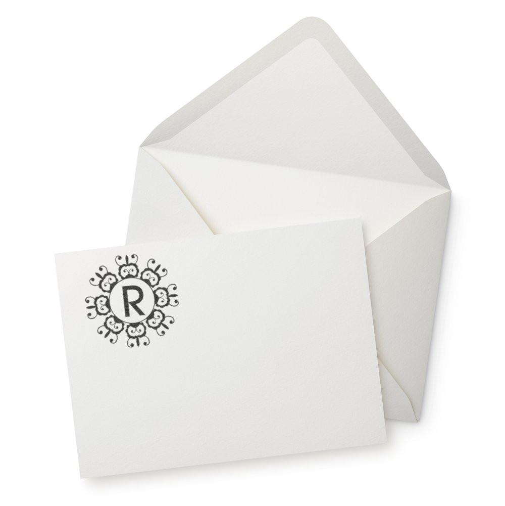 Custom monogram rubber stamp on a white envelope and note card, ideal for personalized stationery and wedding invitations.