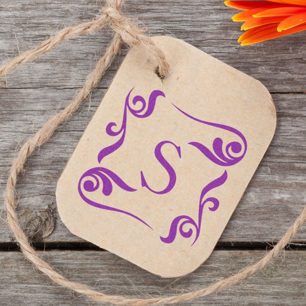 Purple Ganesha yoga symbol on kraft gift tag tied with twine on rustic wooden background, decorative spiritual wall art.