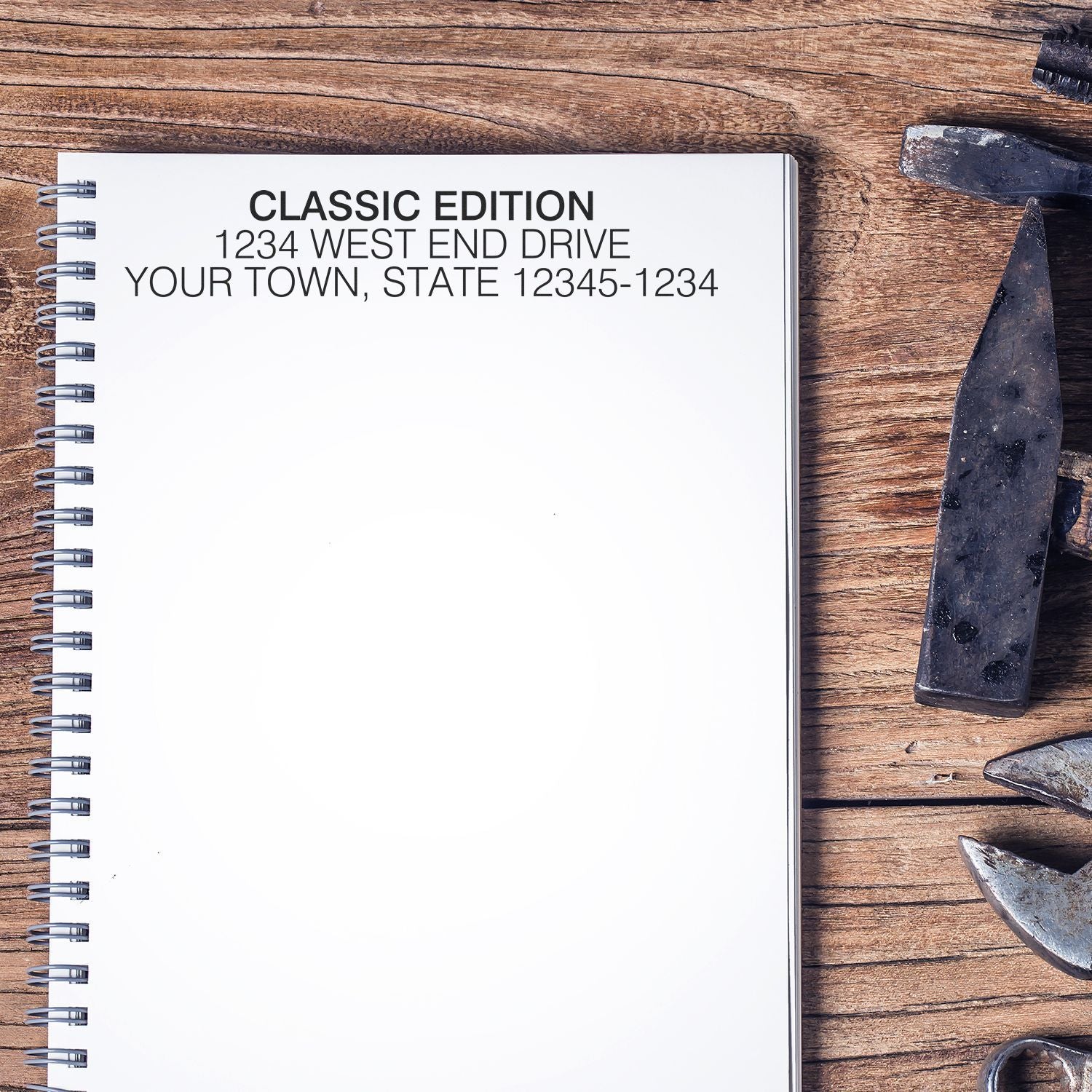 Classic edition address label on spiral notebook mockup on rustic wooden workbench with tools, for custom stationery branding.