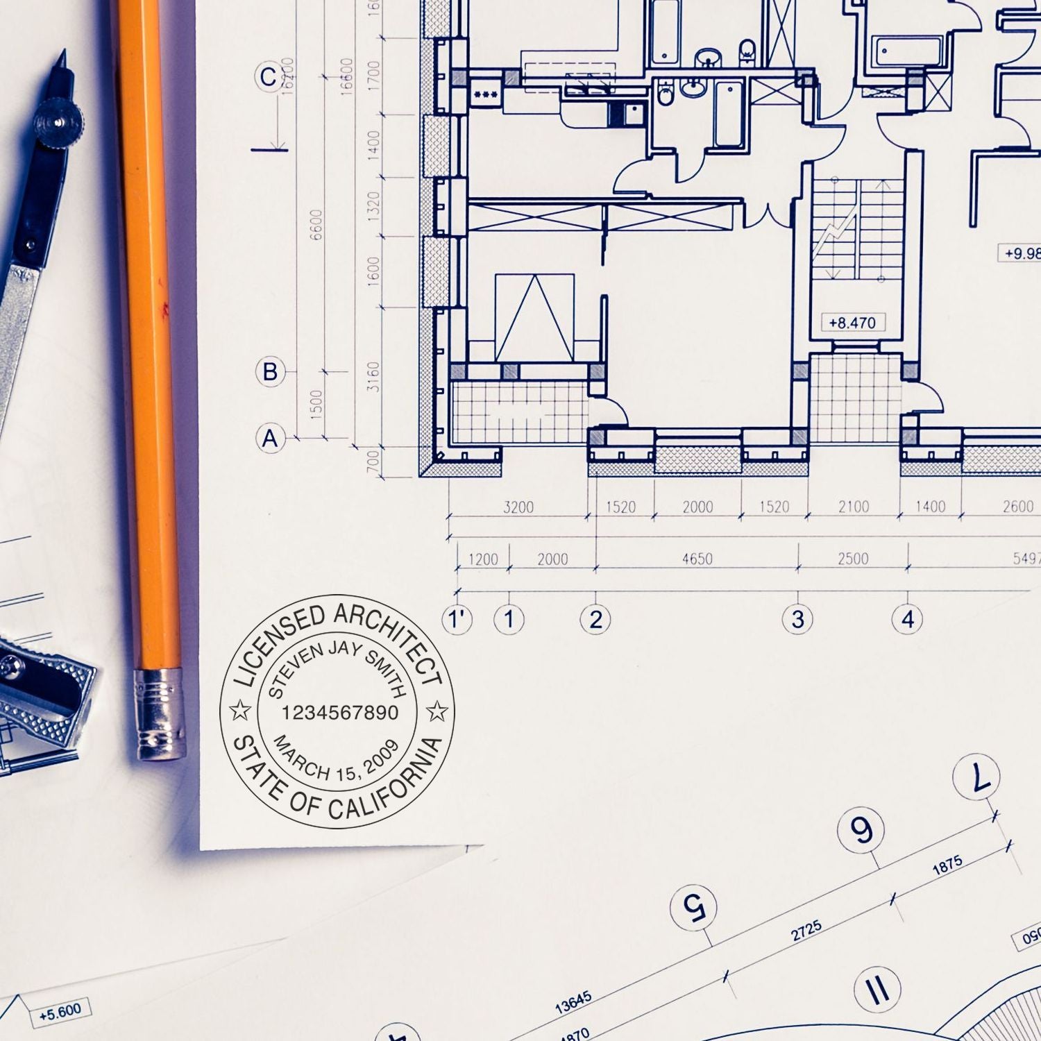 Architectural blueprint with drafting tools, pencil, and licensed architect stamp on a detailed floor plan.